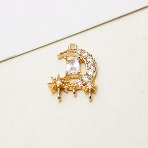Detailed macro view of a gold-plated crescent moon pendant with embedded zircons