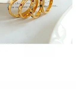 Detail of four gold-plated rings set with colorful red, green, and blue zircons