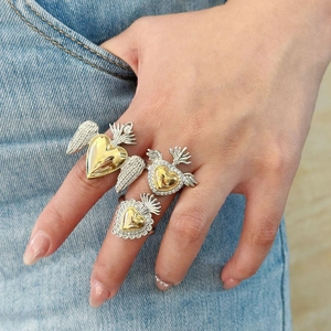 Gothic sacred heart rings with golden wings and zircon stones worn by a model