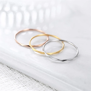 Macro view of 1mm geometric faceted rings in silver, gold, and rose gold finishes.