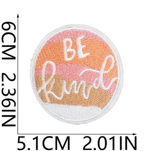 Macro detail of 'BE Kind' embroidered patch showing precise fabric texture and 6cm height
