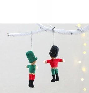 Detail of red and green plush nutcracker soldier ornaments with gold sequins for Christmas