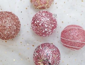 Macro view of rose gold Christmas ball ornaments with sequins, pearls and glitter details