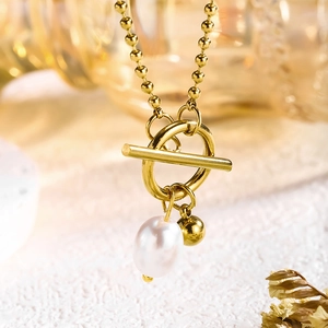 Detail of 18k gold plated T-bar clasp necklace with irregular pearl and gold bead