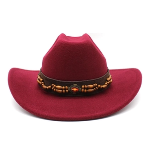 Détail du chapeau en laine rouge foncé avec ruban perlé et pierre orange sertie