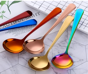 Détail de six cuillères rondes colorées en acier inoxydable poli sur fond marbre