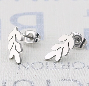 Macro detail of silver leaf shaped stud earrings featuring intricate wheat ear patterns