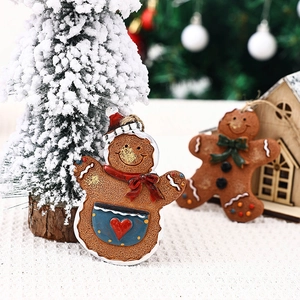 Detailed macro view of resin gingerbread man ornament with red scarf on Christmas tree