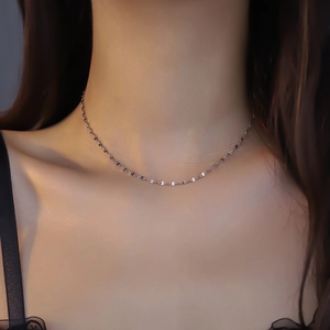 Dettaglio della sottile catena in acciaio inossidabile argento sulla clavicola