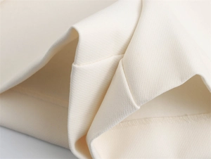 Detailaufnahme der cremefarbenen asymmetrischen Hosenrock mit Fokus auf Stoff und Nähten