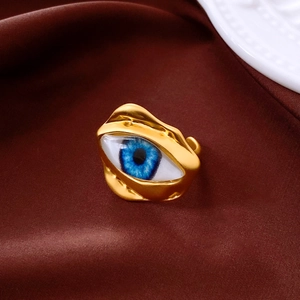 Detail of vintage golden evil eye ring on silk with embossed porcelain accents