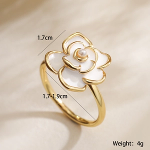 Macro detail of 18K gold-plated flower ring with white enamel petals and pearl center