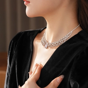 Close-up of teardrop purple gemstone necklace with silver filigree and zircon stones