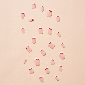 Pink blush press-on nails with white French tips and red heart patterns set