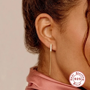 Close-up of 925 sterling silver tassel earring with sparkling cubic zirconia on model