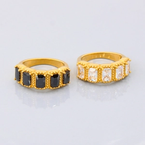 Detailed view of gold plated titanium rings with black and white rectangular zircon stones