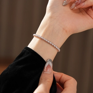 Detailed view of elegant purple beaded pearl bracelet worn on wrist for a vintage look