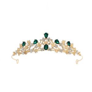 Close-up of golden baroque tiara featuring green teardrop crystals and white rhinestones