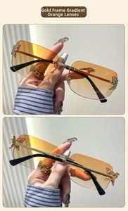 Detail of rimless Y2K butterfly sunglasses with golden frame and orange gradient lenses