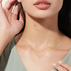 Close-up of minimalist S925 sterling silver gold chain with round opal pendant on neck
