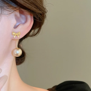Elegant bow knot earrings with pearl drop on female model for a luxury look