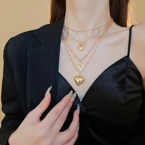 Golden multi-layer layered necklace featuring heart pendants and world map globe charm