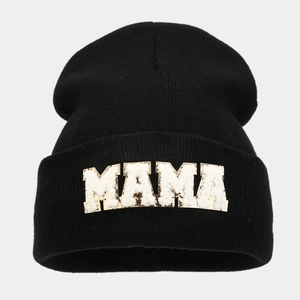 Detail of black knit beanie featuring white towel embroidered MAMA letter patch