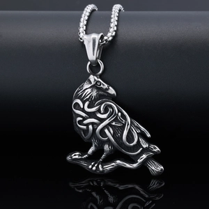 Macro detail of silver owl pendant with Celtic knotwork and polished steel square chain