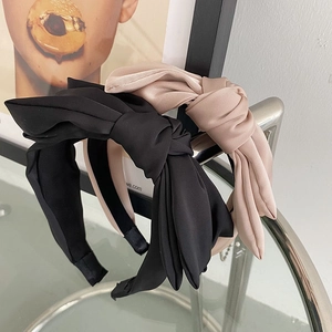 Detail of satin bow headbands in black and champagne with elegant silk texture