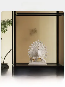 Detail of creative peacock ornament with white ceramic finish and golden feather accents