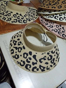 Detail showing beige straw sun visor with leopard print and wide brim measurement
