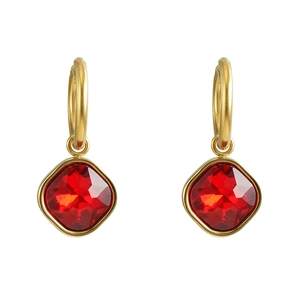 Détail de créoles dorées en titane avec pendentifs en zircon rouge carré sur fond blanc