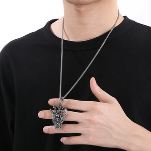 Gothic silver stainless steel necklace featuring a demon claw gripping a skull pendant