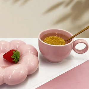 Detail of pink macaron ceramic coffee cup and sunflower petal saucer set
