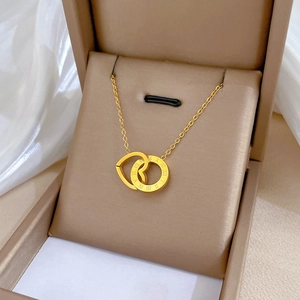 Dettaglio della collana in acciaio al titanio dorato con anelli a cuore e numeri romani