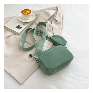 Detail of light green oxford shoulder bag with mini coin purse on adjustable strap