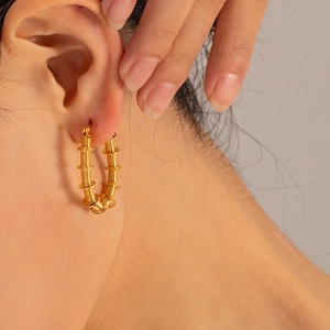Eleganti orecchini a cerchio a U in acciaio inossidabile placcato oro 18K su una modella