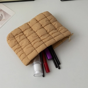 Chic quilted puffer cosmetic bag in khaki with a gold zipper and makeup tools inside