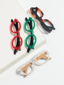Detail of four colorful acetate eyeglass brooches including red, green, and tortoiseshell