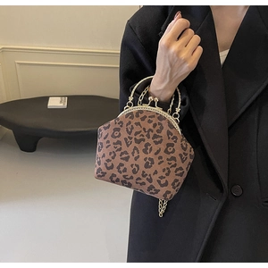 Detail of leopard print shell bag with golden metal frame clasp and chain handle