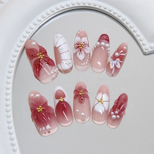 Faux ongles rose blush avec fleurs de camélia 3D et perles sur pointes ovales