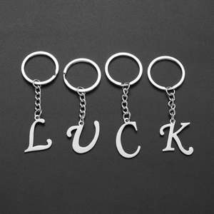 Silver stainless steel LUCK letter keychains on a black background for daily use