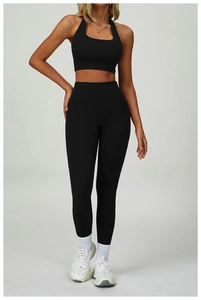 Vertical full-body shot of a black yoga set with a halter vest and high-waist leggings