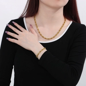 Poliertes Gold-Edelstahl Figaro Kette und Armband Set, präsentiert von einem Model