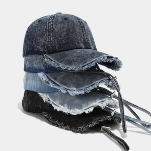 Détail de casquettes de baseball en denim délavé avec bords usés et longues lanières