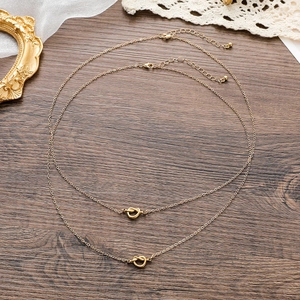 Macro detail of 18k gold plated knot pendant with delicate chain on vintage background