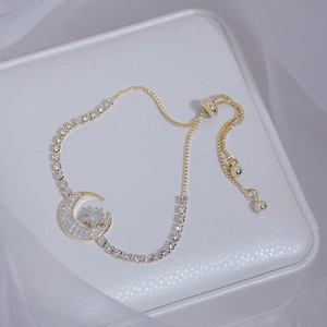 Gold star and moon zircon bracelet with adjustable box chain on white leather box