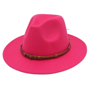 Close-up of pink wool fedora hat featuring a brown leather band and metal skull buckle