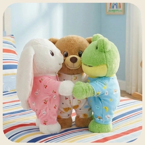 Three plush animals in colorful printed pajamas standing on a bed in a cozy bedroom