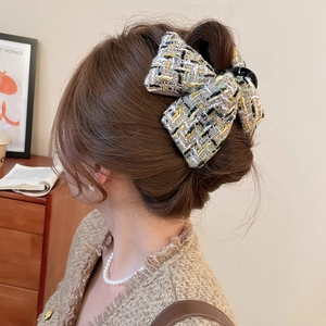 Pince à cheveux élégante en tweed multicolore portée sur un chignon classique